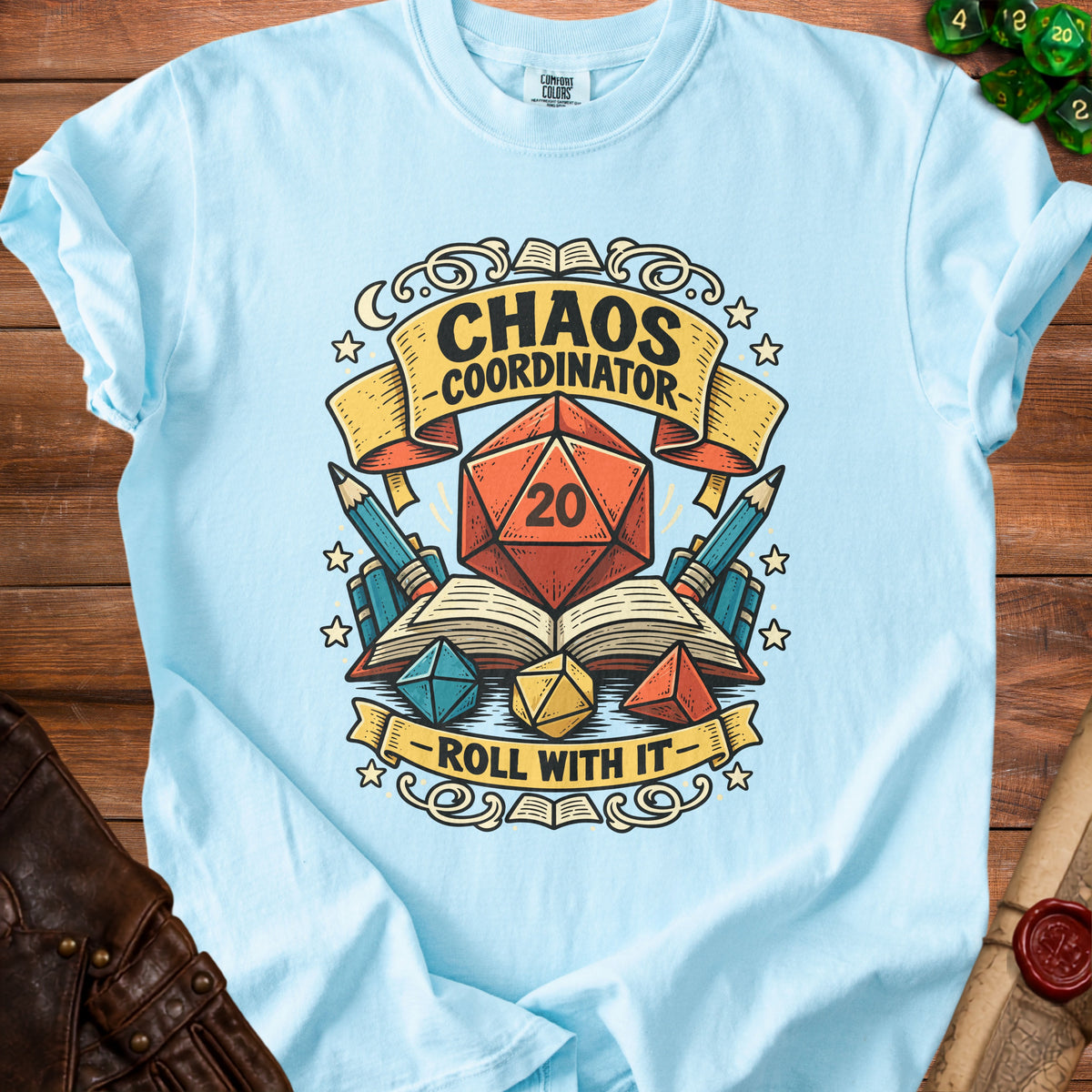 Light blue t-shirt with "Chaos Coordinator Roll With It" text and dice graphics.