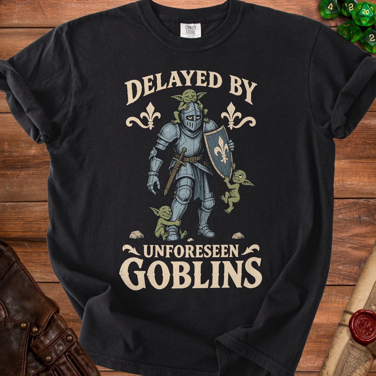 Black t-shirt with knight surrounded by goblins, text "Delayed By Unforeseen Goblins".
