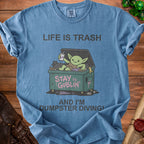 Blue t-shirt with a graphic of a goblin in a trash can and text "Life is Trash" and "Stay Goblin".