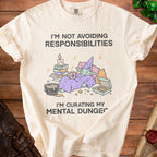 Cream t-shirt with graphic: "I'm not avoiding responsibilities, I'm curating my mental dungeon."