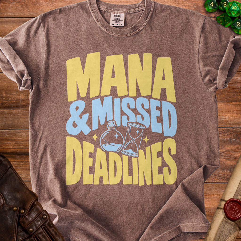 Brown t-shirt with yellow and blue text reading "Mana & Missed Deadlines".