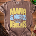 Brown t-shirt with yellow and blue text reading "Mana & Missed Deadlines".