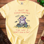 Yellow t-shirt with a cartoon vampire sitting on coffins and text "I must be constipated the way I don't give a shit."