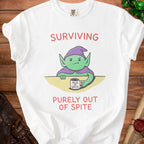 White t-shirt with a green goblin holding a "Mug of Spite" and the text "SURVIVING PURELY OUT OF SPITE".