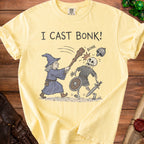 Yellow t-shirt with "I CAST BONK!" text and wizard fighting a skeleton.