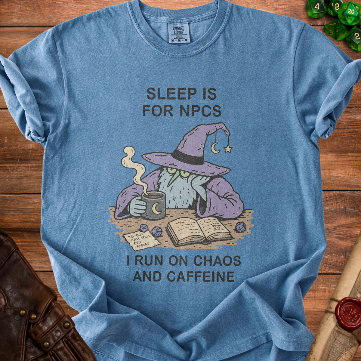 Blue t-shirt with a wizard graphic and text "SLEEP IS FOR NPCS I RUN ON CHAOS AND CAFFEINE".