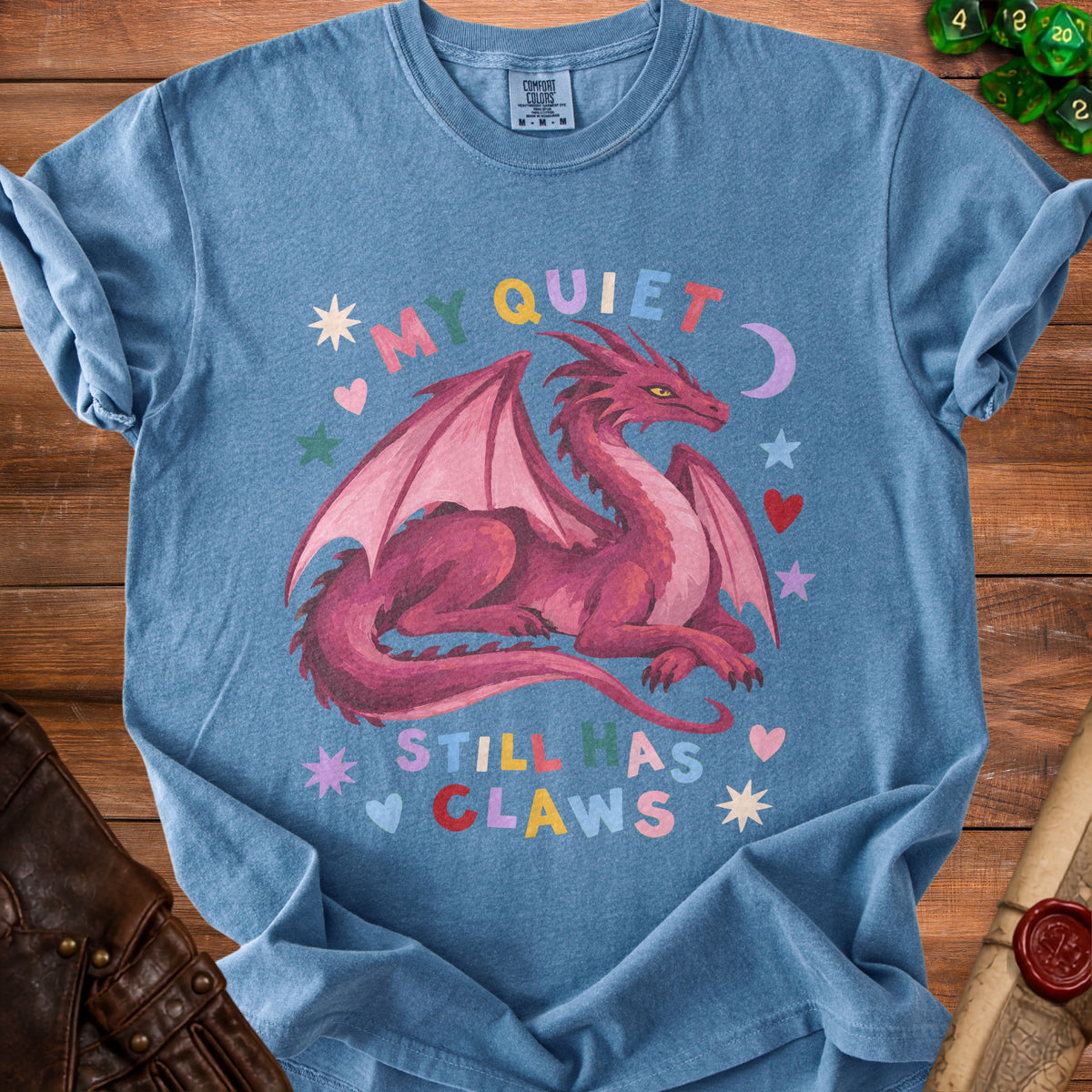 Blue t-shirt with a pink dragon and text "MY QUIET STILL HAS CLAWS".