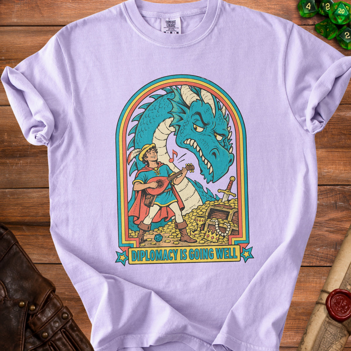 Light purple t-shirt with a cartoon of a lute-playing bard facing a dragon and text saying "Diplomacy is going well."