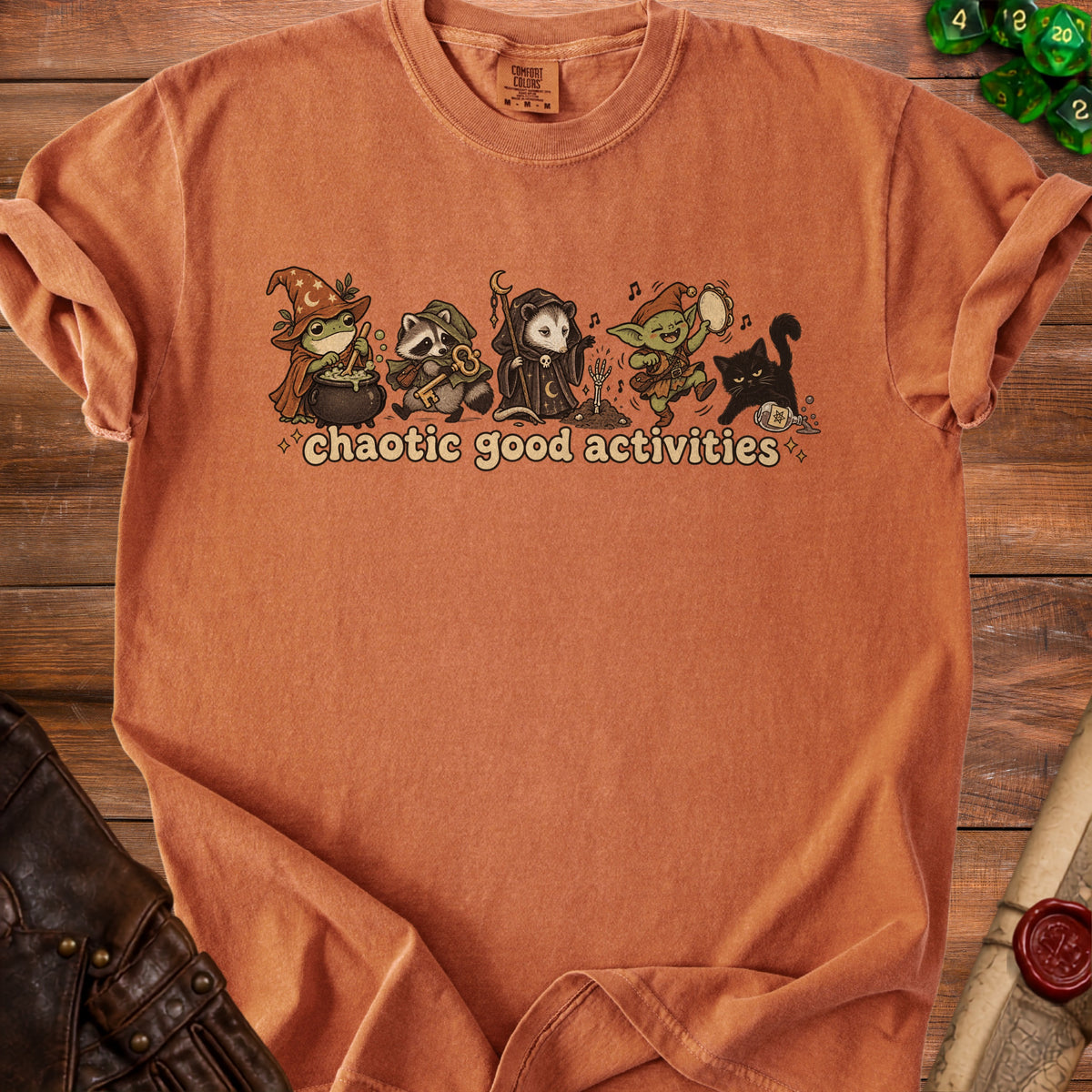 Terracotta t-shirt with cartoon frog, raccoon, opossum, goblin, and black cat in "chaotic good activities" design.