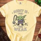 Light yellow t-shirt with a cartoon goblin holding a mace, text "Mercy is for the weak".