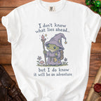White t-shirt with frog wizard graphic and text "I don't know what lies ahead... but I do know it will be an adventure"