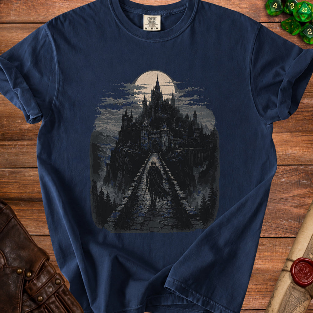 Dark blue t-shirt with a pixel art graphic of a cloaked figure on a bridge approaching a gothic castle under a full moon.