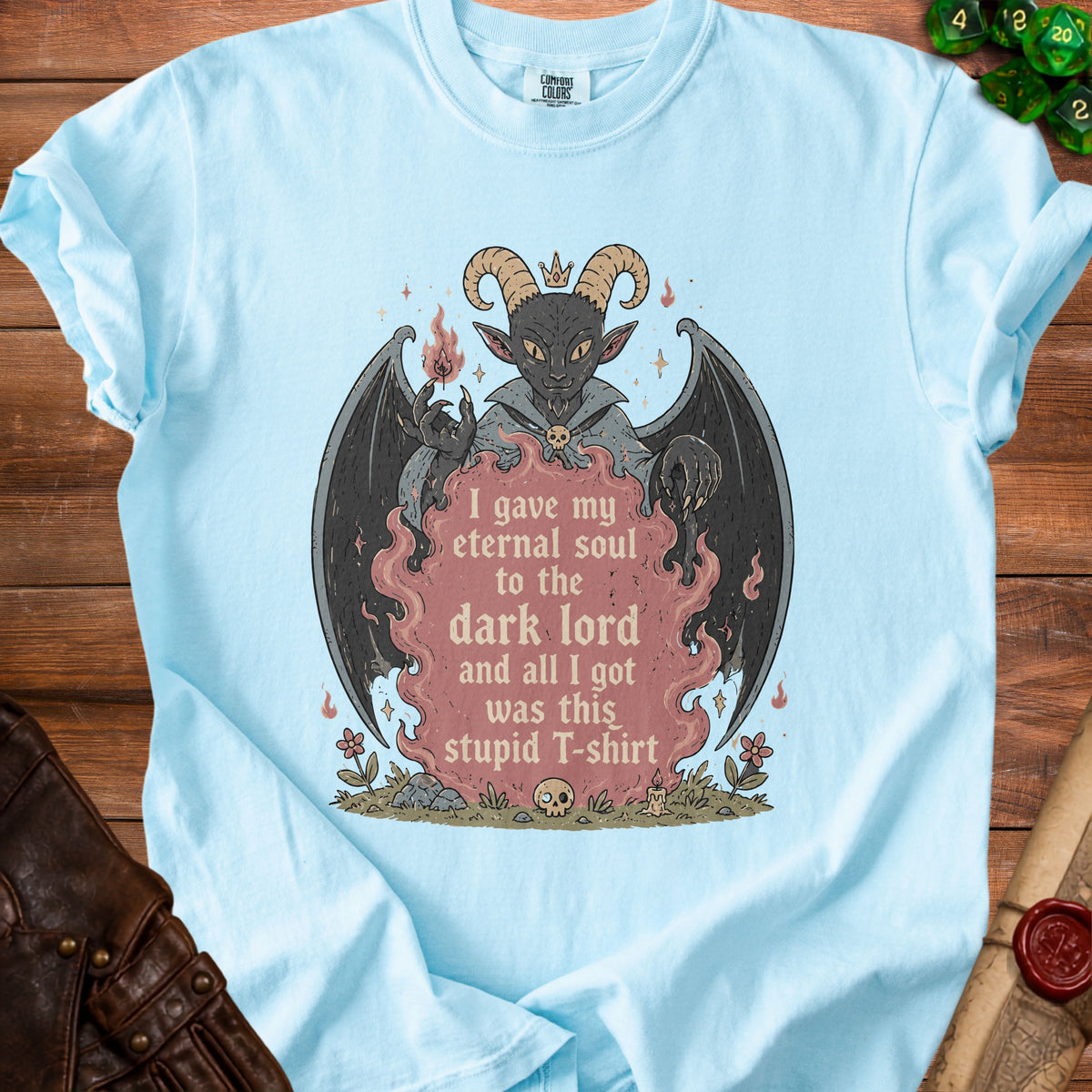 Light blue t-shirt with a graphic of a demon holding a flame and text.
