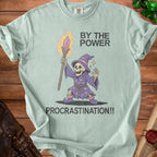 Light blue t-shirt with graphic of skeleton wizard and text "BY THE POWER PROCRASTINATION!!".
