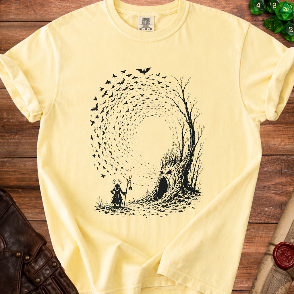 Yellow t-shirt with black graphic of a deer-headed figure and a tree with a face and bats.
