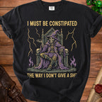 Black t-shirt with skeleton wizard sitting on a throne, text reads "I MUST BE CONSTIPATED THE WAY I DON'T GIVE A SHI".