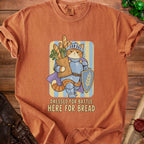 Orange t-shirt with cartoon knight cat holding bag of bread, text "DRESSED FOR BATTLE HERE FOR BREAD".