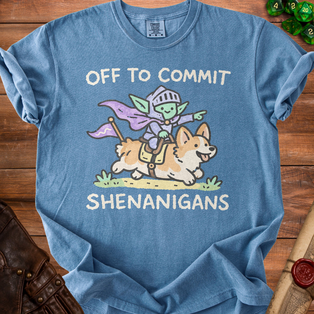 Blue t-shirt with cartoon knight goblin riding a corgi, says "Off to commit shenanigans".