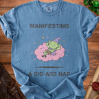 Blue t-shirt with "Manifesting A Big Ass Nap" and a sleeping gnome on a cloud.