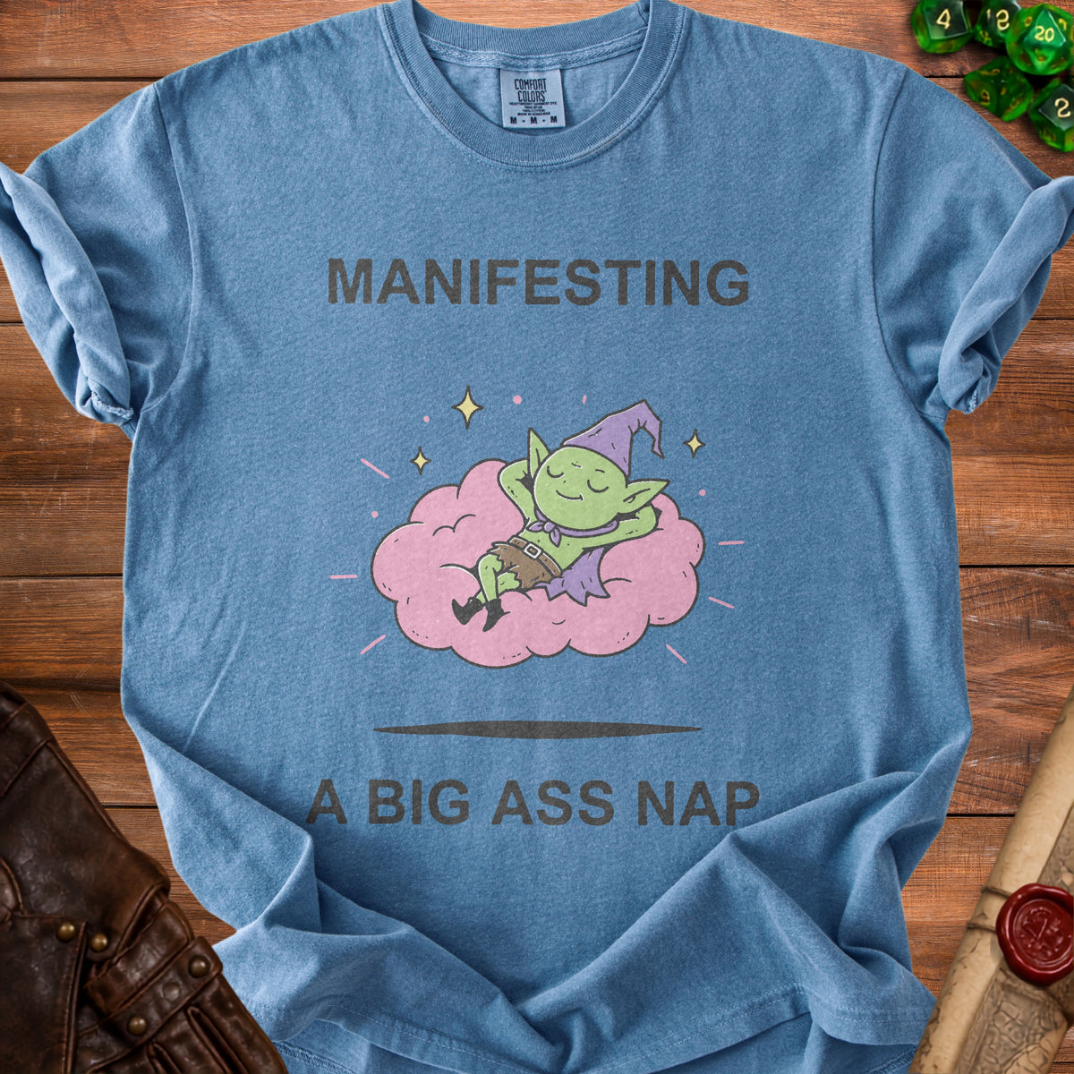 Blue t-shirt with "Manifesting A Big Ass Nap" and a sleeping gnome on a cloud.