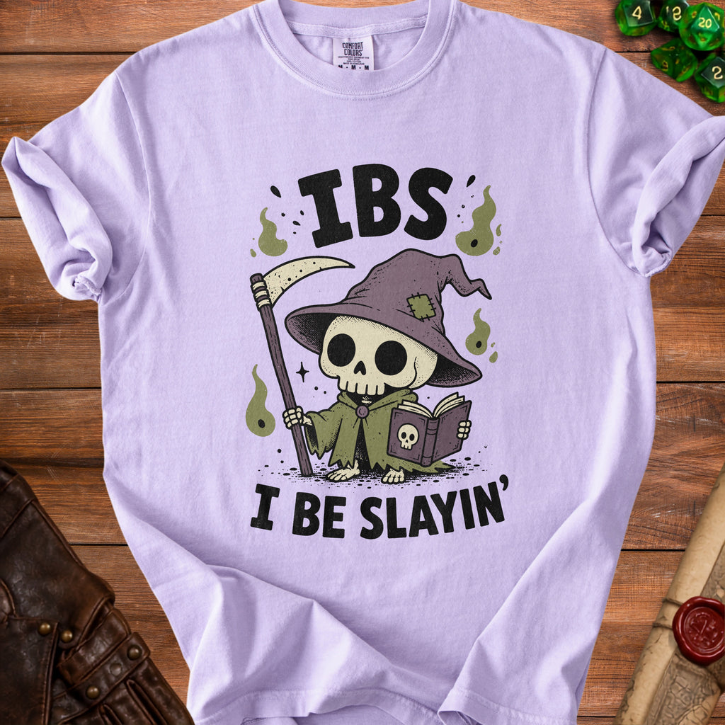 Lilac t-shirt with a cartoon grim reaper reading a book and text "IBS I BE SLAYIN'".