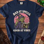 Goblin wizard with book and text "BAD AT SPELLS GOOD AT VIBES".