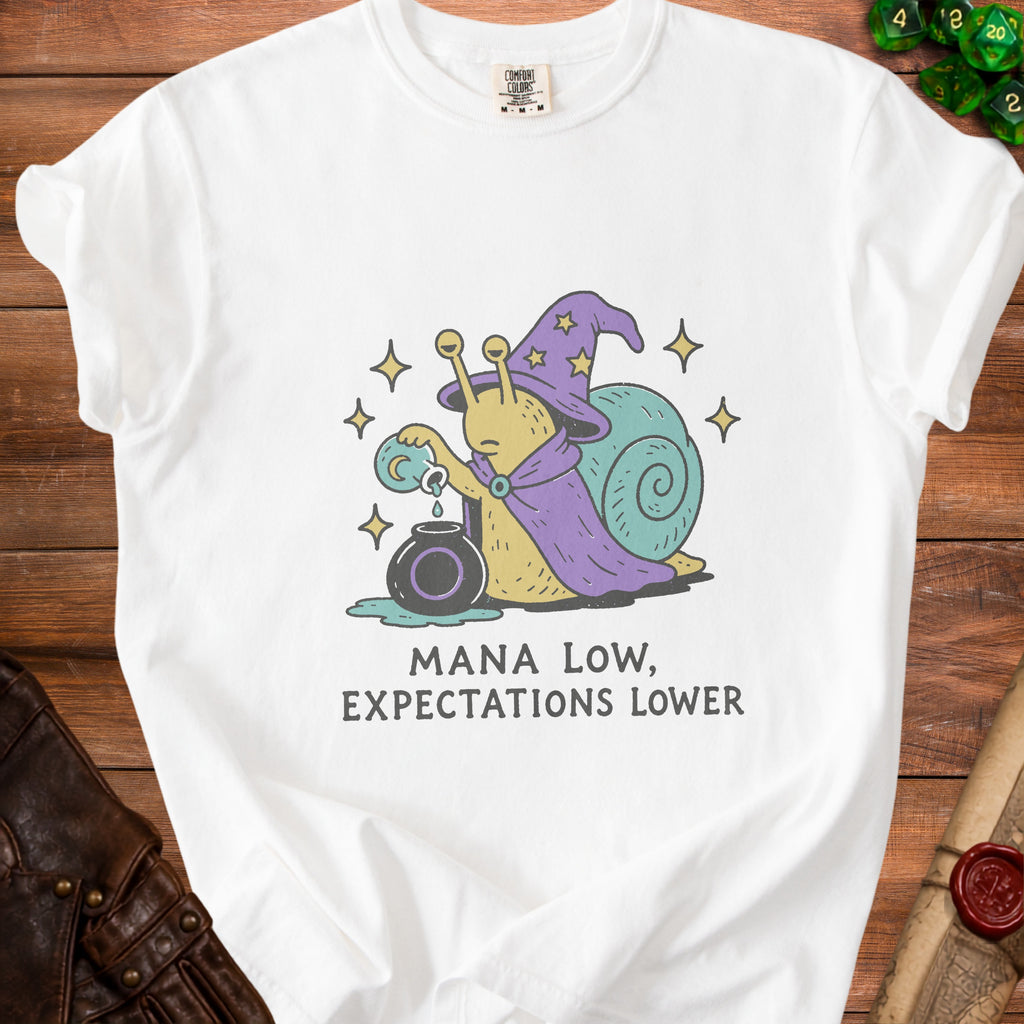 White t-shirt with a wizard snail pouring potion and text "MANA LOW, EXPECTATIONS LOWER".