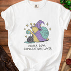 White t-shirt with a wizard snail pouring potion and text "MANA LOW, EXPECTATIONS LOWER".