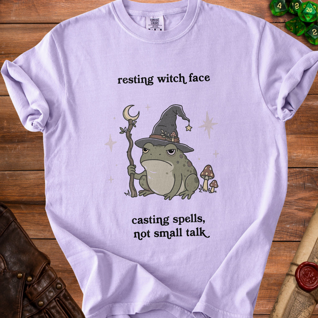 Lavender t-shirt with graphic of a grumpy frog in a witch hat, holding a staff, and text.
