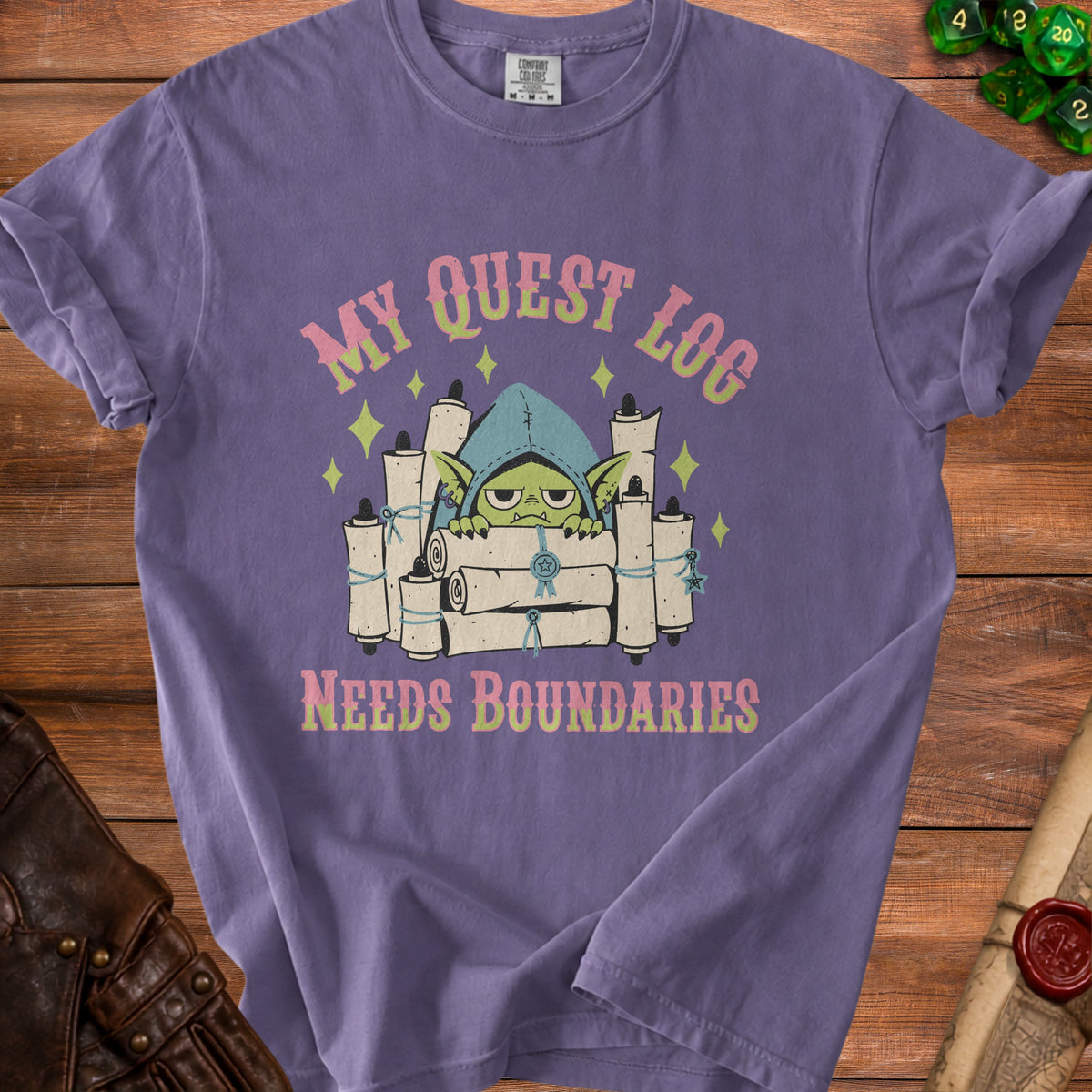 Purple t-shirt with graphic of a grumpy goblin and text "MY QUEST LOG NEEDS BOUNDARIES".