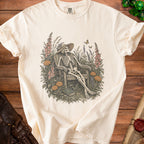 Cream t-shirt with skeleton relaxing in a garden with butterflies.