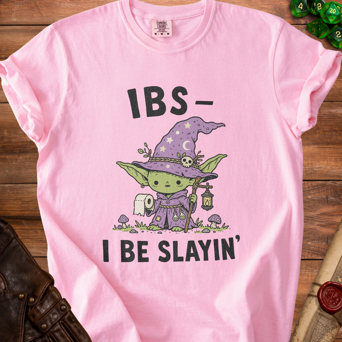 Pink t-shirt with a cartoon witch holding toilet paper and the text "IBS- I BE SLAYIN'".
