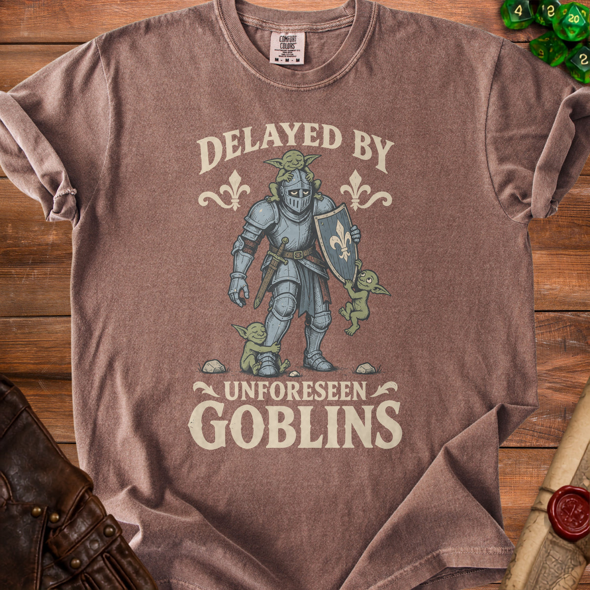 Brown t-shirt with a knight and goblins graphic and "Delayed by Unforeseen Goblins" text.