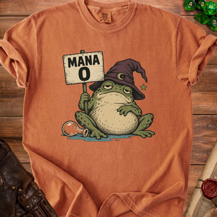 An orange t-shirt displays a graphic of a sleepy frog wearing a wizard hat, holding a Mana 0 sign.