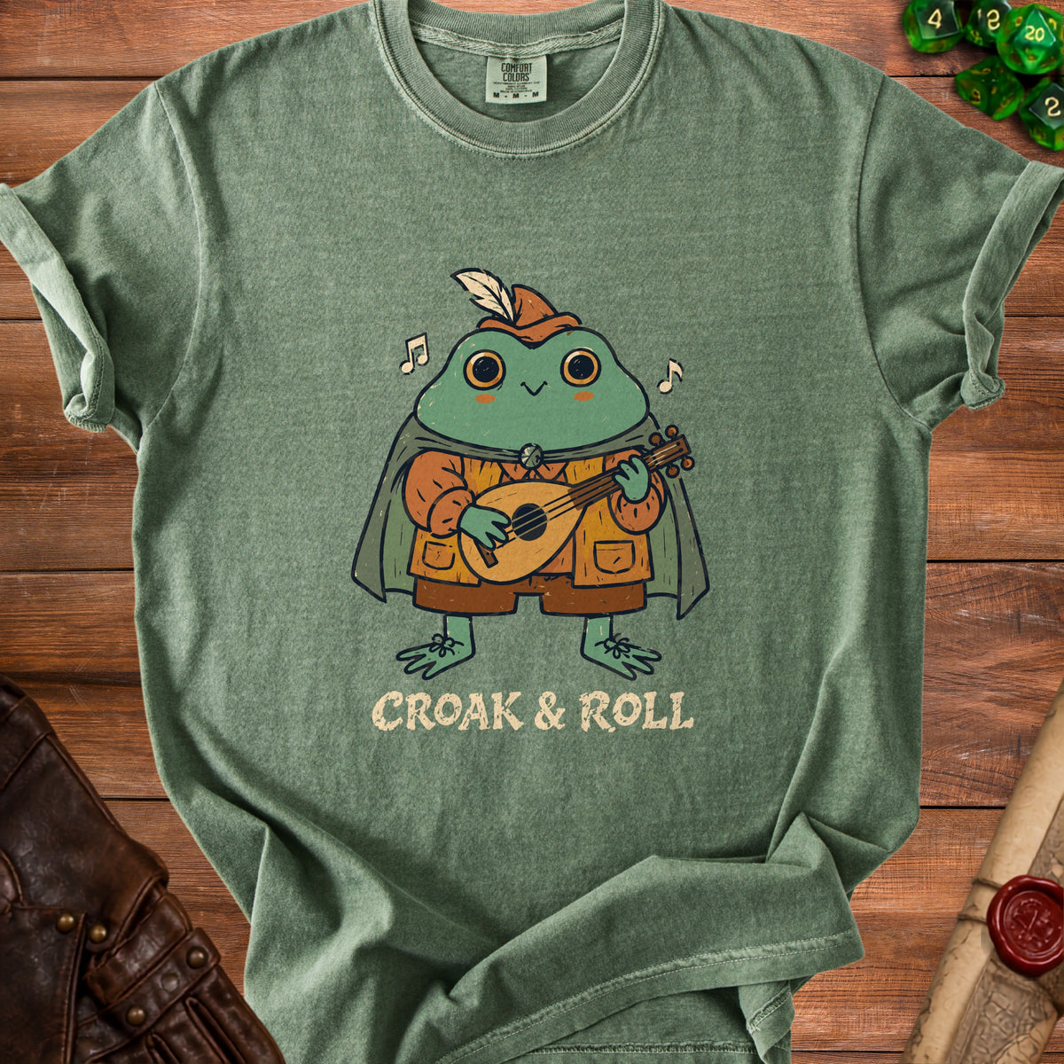 Green t-shirt with a cartoon frog playing a lute, text reads "CROAK & ROLL".