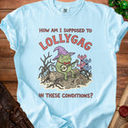 Light blue t-shirt with a frog wearing a wizard hat playing banjo, text "How am I supposed to lollygag in these conditions?".