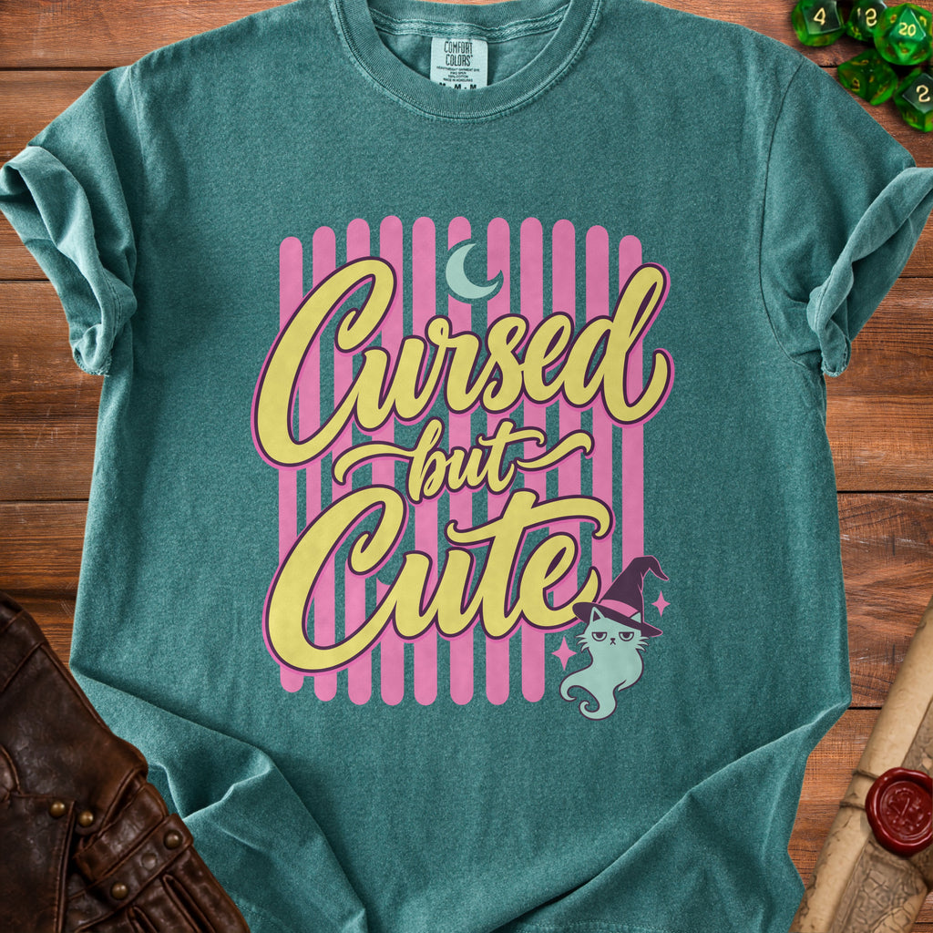 Teal t-shirt with "Cursed but Cute" text and a cartoon ghost cat.