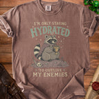 T-shirt with raccoon drinking from goblet, "I'm only staying hydrated to outlive my enemies."