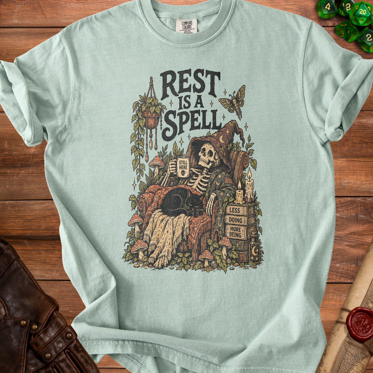 Skeleton in witch hat drinking coffee with cat; text "REST IS A SPELL".