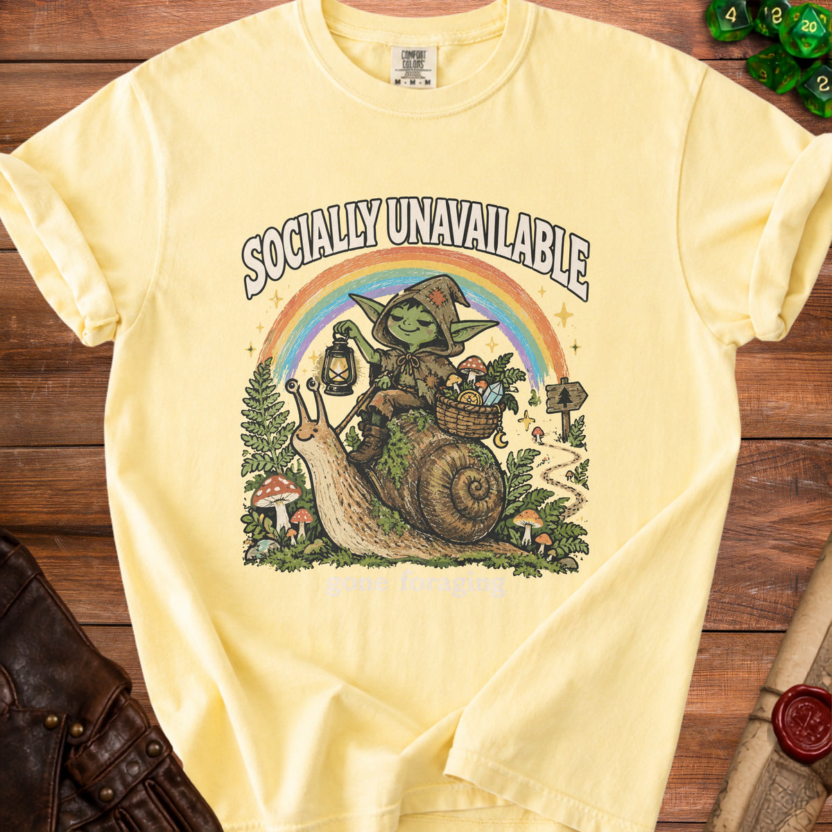 Yellow t-shirt with gnome on snail graphic, rainbow, and "Socially Unavailable" text.