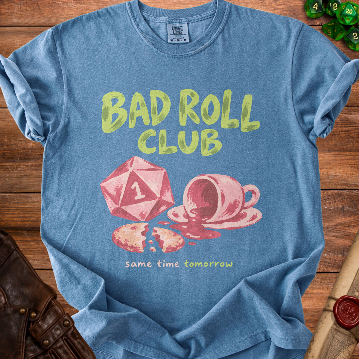 Blue t-shirt with "Bad Roll Club" text, dice, spilled coffee, and cookie graphic.