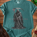 Grim reaper with scythe and pink bow on shirt reads "IN MY VILLAIN ERA".