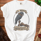 A white t-shirt featuring a vintage illustration of a raven perched on chess pieces, with text reading A Most Satisfying Downfall.