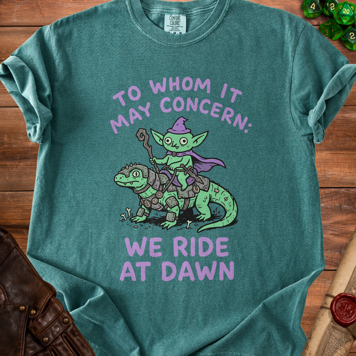 Green t-shirt with purple text and cartoon of a goblin riding a dinosaur.