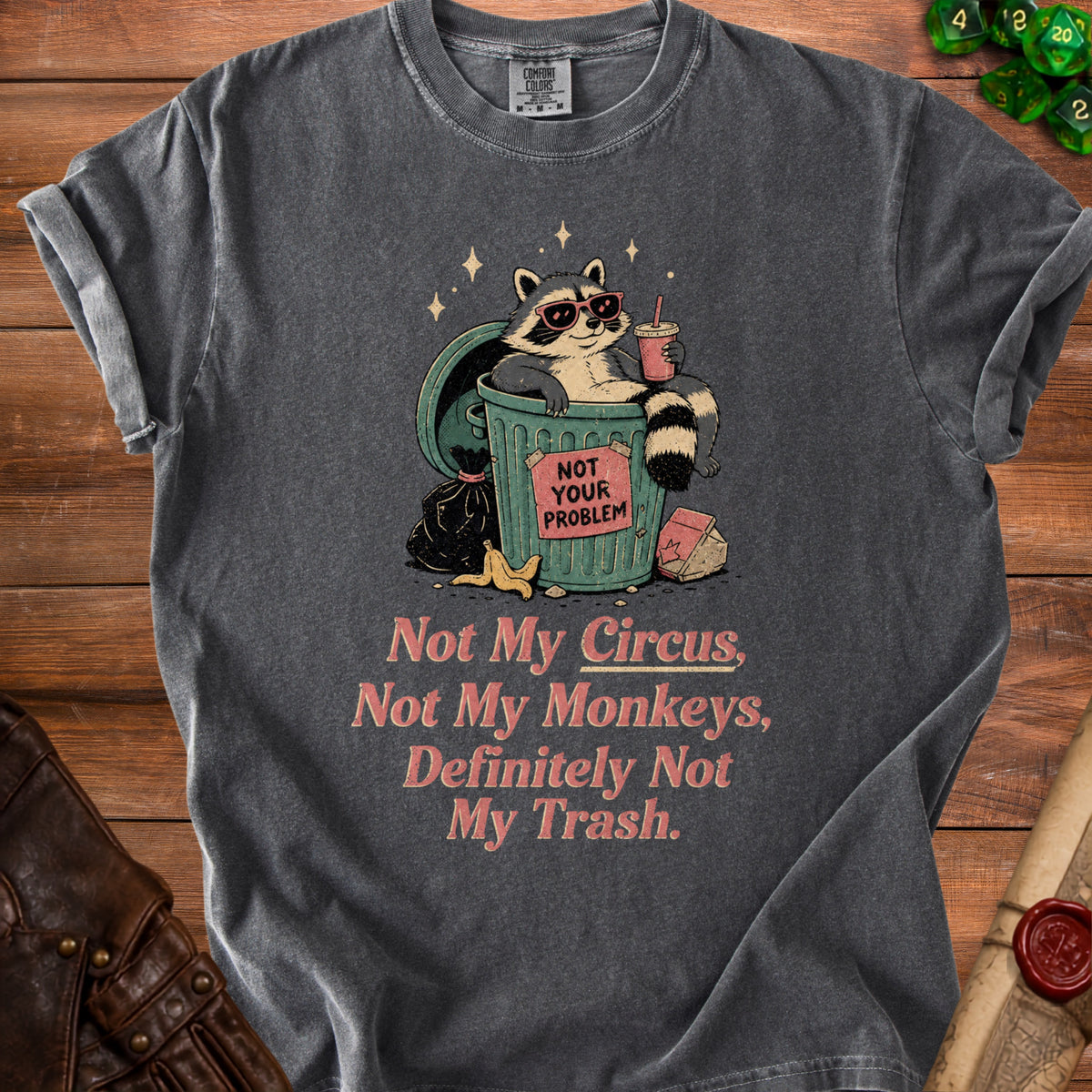 Charcoal t-shirt with a raccoon in sunglasses in a trash can with text.