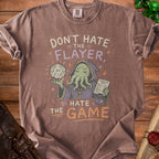 Brown t-shirt with graphic text "Don't Hate the Flayer, Hate the Game".