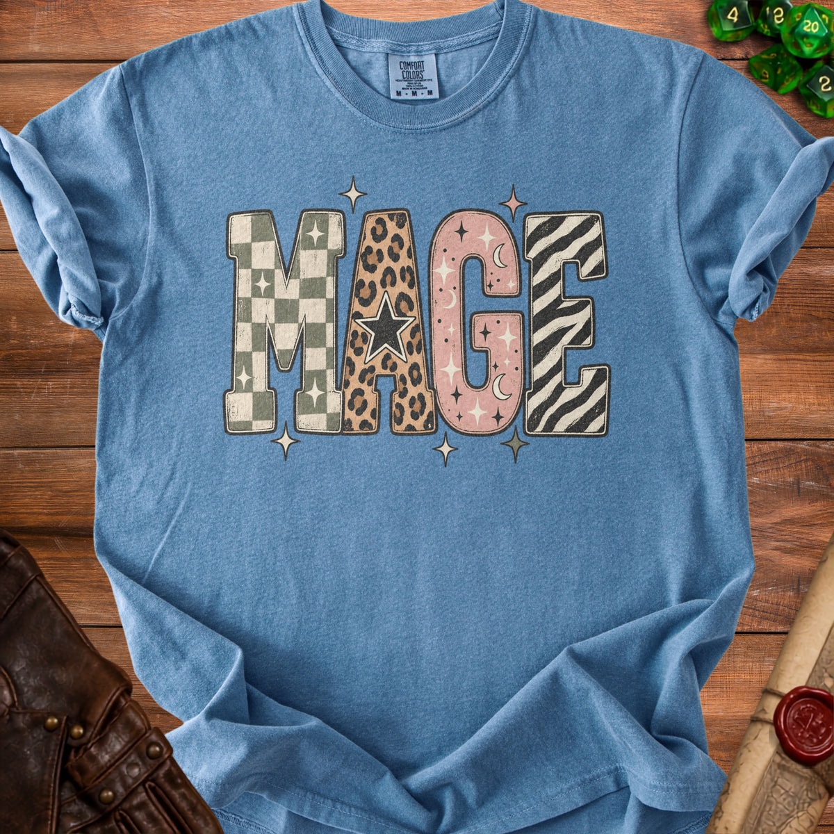 Blue t-shirt with "MAGE" text in patterned, distressed letters.