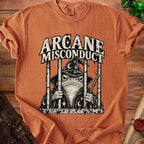 T-shirt with a wizard frog in jail design and "Arcane Misconduct" text.