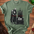 Green t-shirt with knight and cat on throne graphic, "I HAD PLANS" text.