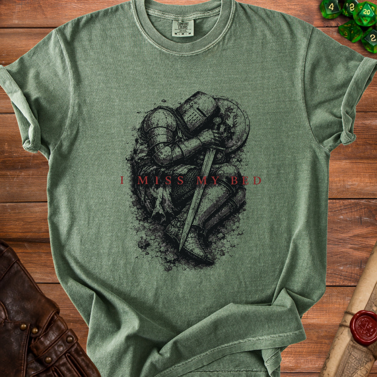 Green t-shirt with distressed graphic of knight kneeling and text "I MISS MY BED".